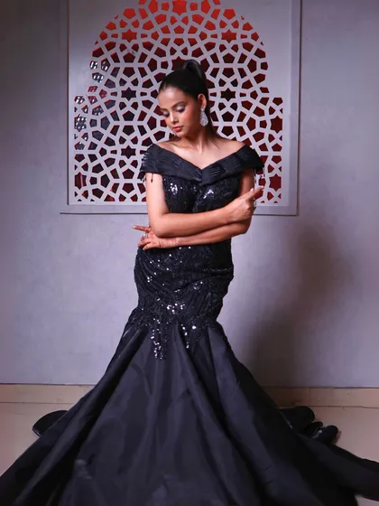 A full-length shot that captures the sleek and stylish silhouette of the black fish-cut gown.