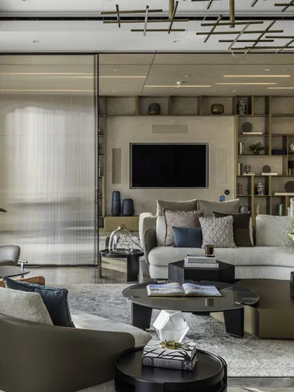 A modern fusion home tailored for a multi-generational family. The living area is a celebration of timeless elegance, where every corner is a seamless blend of comfort and luxury, featuring a curved sofa and a mix of textures and materials.