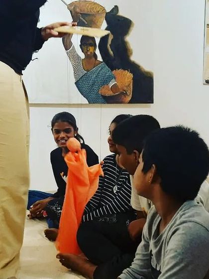 An audience of children watches as a hand puppet interacts with a boy in a pilot costume. The smiles on their faces say it all.