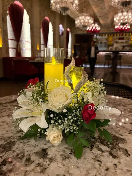 An elegant table centerpiece for a classy anniversary dinner. The arrangement includes white and red roses, baby's breath, and flameless candles for a romantic and safe ambiance.