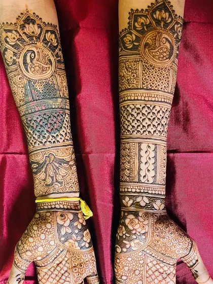 This design features bold peacock motifs at the top, with a mix of checkerboard and floral patterns filling the rest of the arms. A great example of combining different traditional elements.
