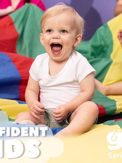 We build confident kids, starting from the very beginning. The pure joy on this baby's face during a group parachute game shows how our activities foster security and self-assurance.