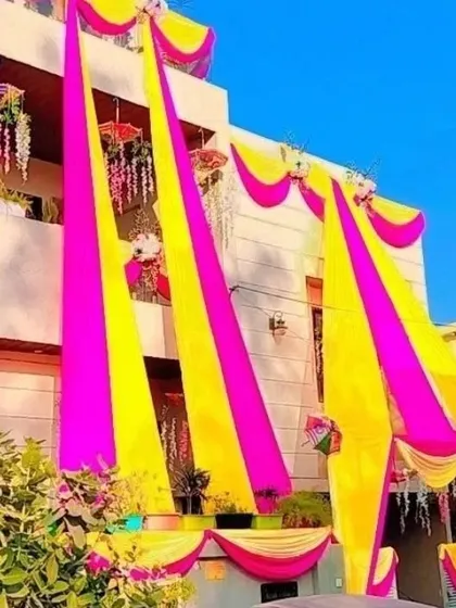 Our services include full house exterior decoration. We use long, flowing fabric drapes in vibrant colors like yellow and pink to create a festive and welcoming look for your entire home.