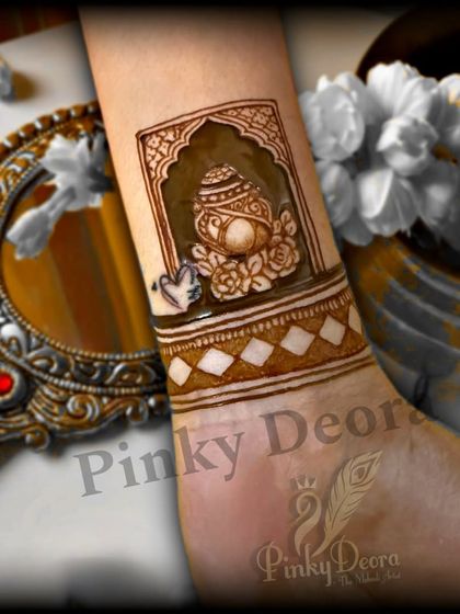 A simple and auspicious design for an engagement, featuring a 'kalash' (ceremonial pot) on the wrist.