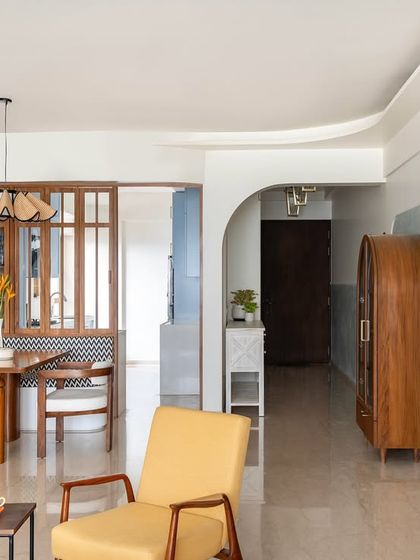This view showcases the open and flowing layout of the home. From the entryway, you can see through to the dining nook and living area, with custom wooden furniture and soft, textured walls creating a cohesive and welcoming journey through the space.