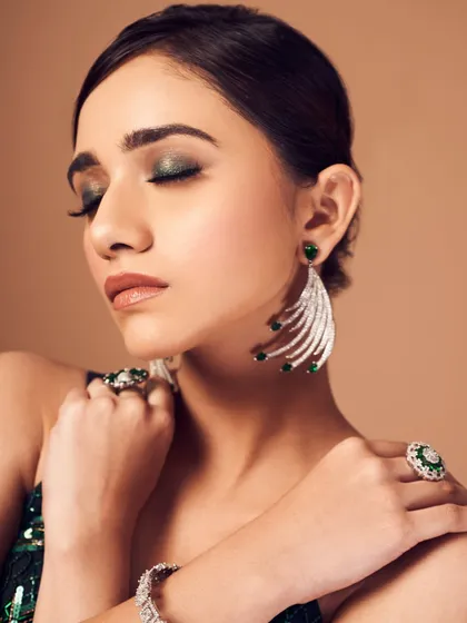 A serene moment showcasing the metallic green eyeshadow. The shimmer catches the light beautifully, adding a touch of magic to the look.