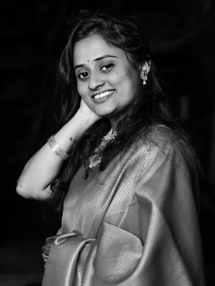 A classic black and white portrait, with the model's hand gently touching her neck, radiating grace and confidence.