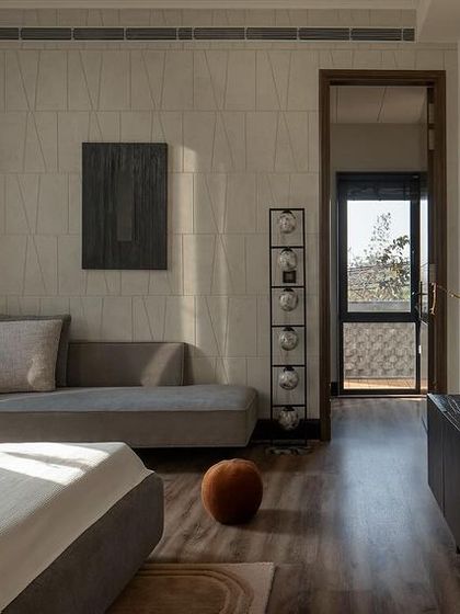 This bedroom reflects the project's minimalist narrative with grey tones and textured wall panels. Organic decor and custom furniture add warmth, while lights made from seashells infuse the space with natural elegance.