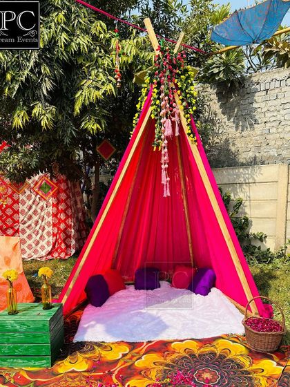 A cozy teepee tent setup for an outdoor Haldi function. This makes for a unique and intimate photo corner for the bride and her friends.
