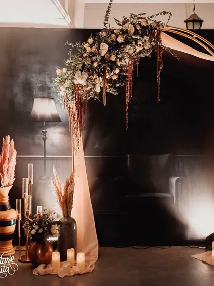 This floral archway served as a beautiful photo backdrop. I used a mix of fresh and dried flowers, including pampas grass, draped with soft fabric and surrounded by candles to create a dreamy, ethereal focal point.