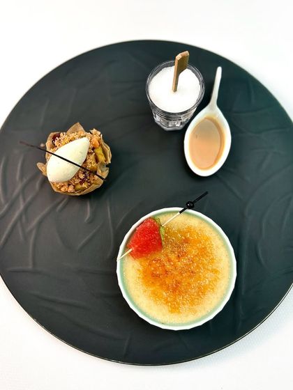 A deconstructed dessert plate from our 15-year celebration menu, featuring a Kinnaur apple and shakarpara crumble, coconut and jaggery brulee, and an Amarula ki chuski.