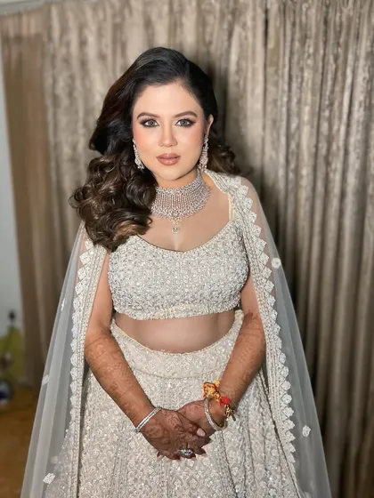 An engagement stunner in a beautiful white lehenga. The makeup is dewy and radiant, with a pop of pink on the cheeks and lips.