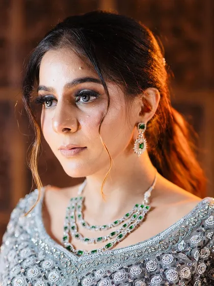 Another beautiful shot of the emerald and diamond jewellery set against the silver lehenga. I can help you find the perfect color contrast for your outfit.