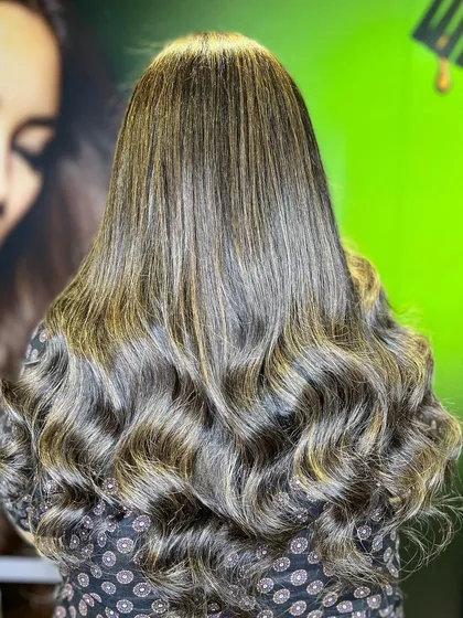 A beautiful example of brunette gold highlights on long, wavy hair.