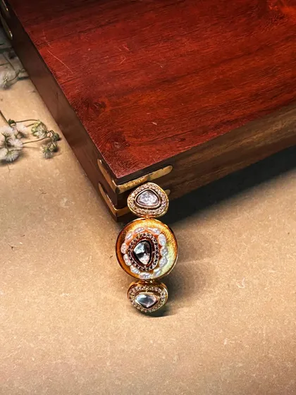 Minimal by size, monumental by presence. A close-up of a unique, elongated ring with three polki diamonds.