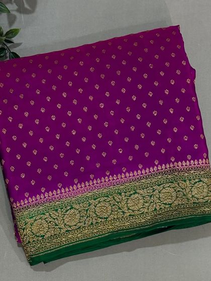A vibrant purple Banarasi crepe saree with a contrasting green and gold border.