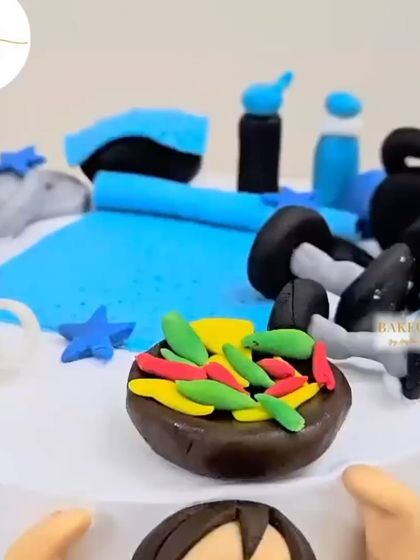 A close-up of the gym-themed cake, showing the tiny fondant details like the kettlebells and the healthy salad bowl.