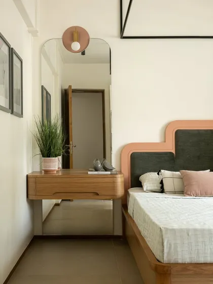 A detail of the dressing area in our Kolam Pop project. The custom vanity is paired with a full-length mirror and a playful, stepped headboard in shades of green and pink.