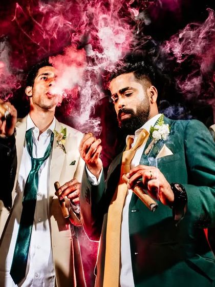 Boys will be boys! The groom and his groomsmen celebrate with cigars, a cool and stylish shot that captures the camaraderie of the group.