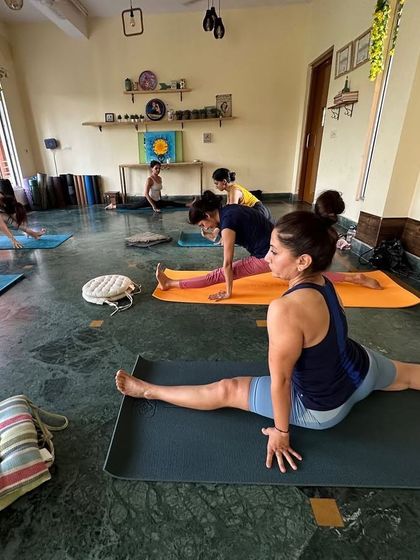 A student works on her Hanumanasana, or splits, during our group class, showing dedication and progress.