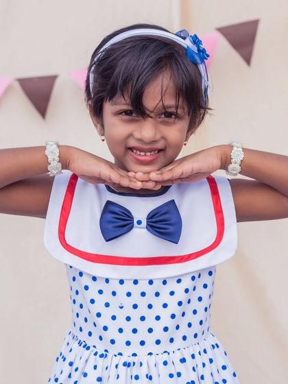A close-up of this charming polka dot sailor dress. The crisp collar and navy bow are classic details that never go out of style.