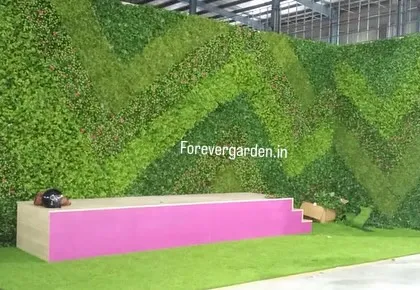 A large-scale, custom-designed green wall with a chevron pattern, created for an event stage backdrop to provide a unique and branded look.