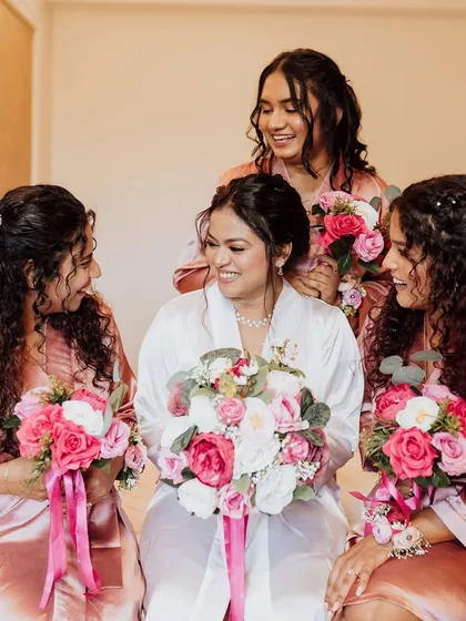 A beautiful, candid moment between the bride and her bridesmaids. It's a joy to create looks for the entire bridal party, ensuring everyone feels special.
