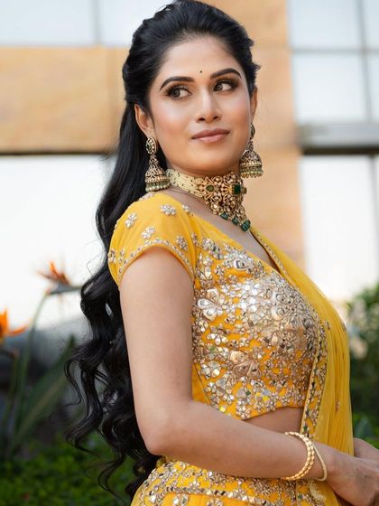 A close-up of the Mehendi look. The makeup is soft and glowing, with a focus on enhancing her natural beauty.