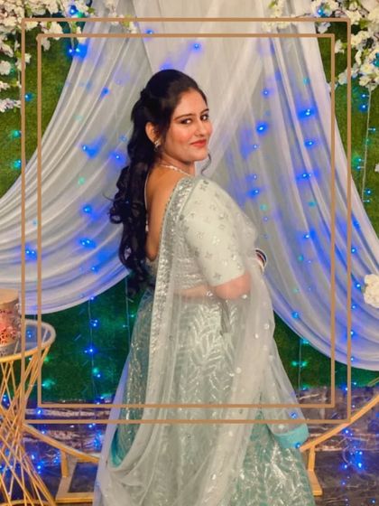 A client looking beautiful from the back in her sea green lehenga, showing off her hairstyle and the outfit's details.