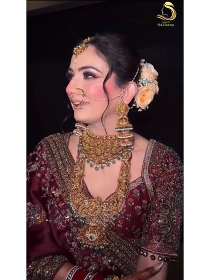 My bride looking radiant with her floral bun, a perfect match for her maroon wedding lehenga.