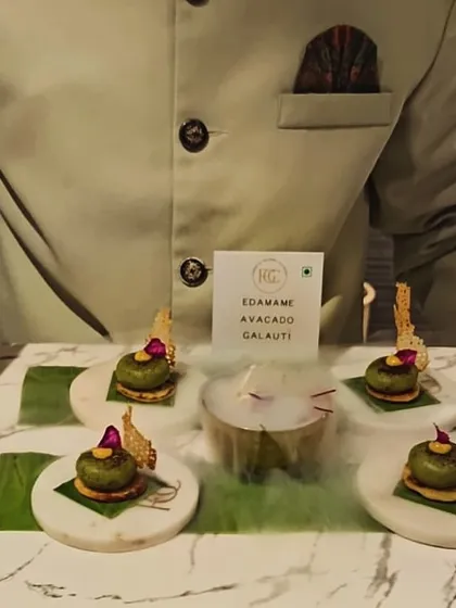 We delight in surprising guests with creative presentations. Here, our Edamame and Avocado Galauti is served with a dramatic dry ice effect, transforming a classic Indian appetizer into a modern culinary moment.