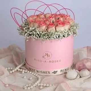 A beautiful shot of a 'Ring-a-Roses' flower box, styled with a pearl necklace to create an elegant and luxurious image for a floral gifting service.