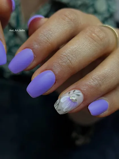 A chic matte purple set with a translucent accent nail featuring a delicate floral design.