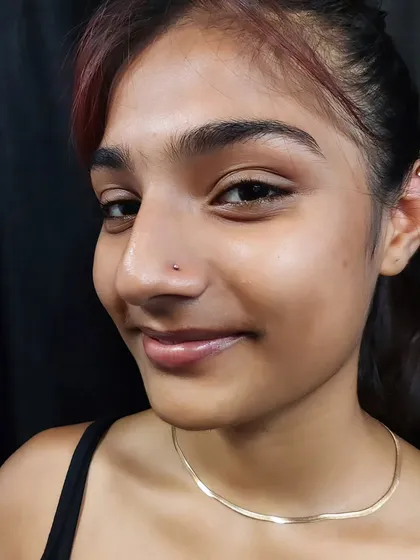 A subtle and classic nostril piercing with a tiny stud for a minimalist look. This is one of the most popular facial piercings I do for clients of all ages.
