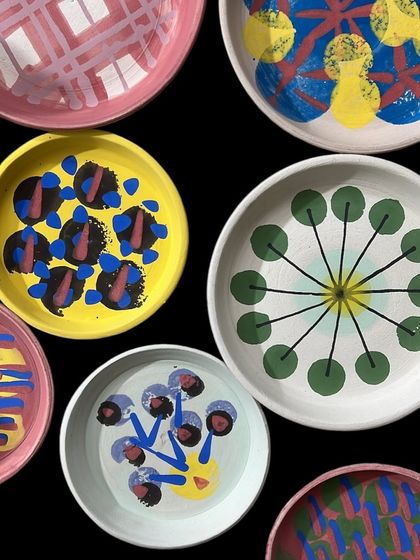 An overhead shot of several plates I've just finished painting. I love exploring different abstract patterns and color combinations before they head to the kiln.