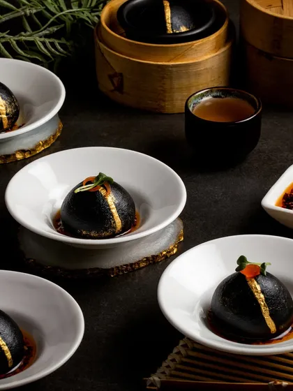 Our activated charcoal Shanghai buns, filled with vegetables and brushed with gold for a dramatic and luxurious presentation. A bun that truly does the talking.
