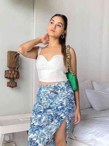 A client enjoying her vacation in my custom white corset top. It's a versatile piece that pairs beautifully with a printed skirt for a beachy, stylish look.