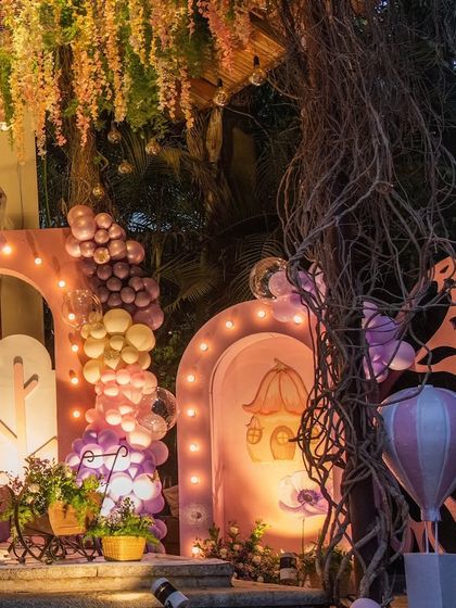 A side view of the enchanted garden theme, showing the layered backdrop, balloon arrangements, and whimsical props that create a sense of depth and wonder.