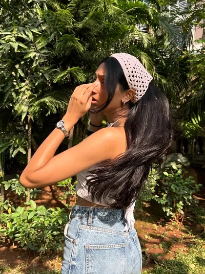 A handmade crochet bandana is a versatile hair accessory. Here it's styled as a headband to keep hair back on a sunny day.