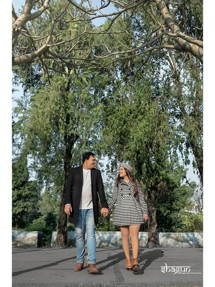 A stylish walk down a beautiful, tree-lined avenue. The couple's coordinated outfits and confident stride make for a chic and modern candid shot.