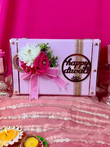 This beautiful pink trunk box is one of our most loved Diwali hampers. It's adorned with a floral arrangement and a 'Happy Diwali' cutout, making it a perfect festive gift.