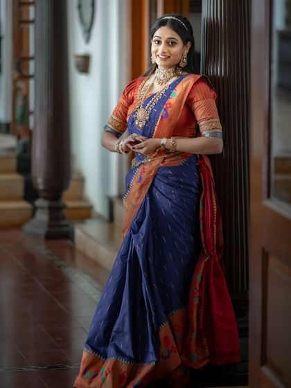 A full-length view of the blue and orange Paithani saree, its regal peacock and lotus motifs speaking the language of tradition.