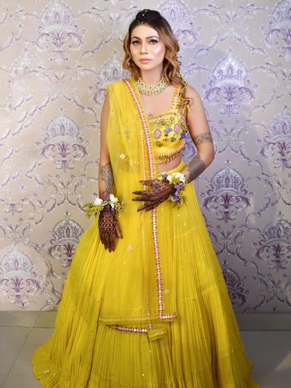 Embracing tradition with intricate Mehendi art. The makeup is kept fresh and glowing to complement the beautiful henna and floral jewelry.