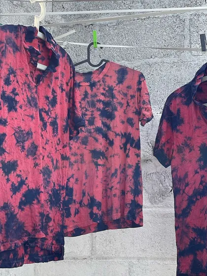 A closer look at a set of shirts upcycled with a bold tie-dye pattern. The contrast between the deep indigo and the vibrant madder red creates a dynamic and eye-catching effect.