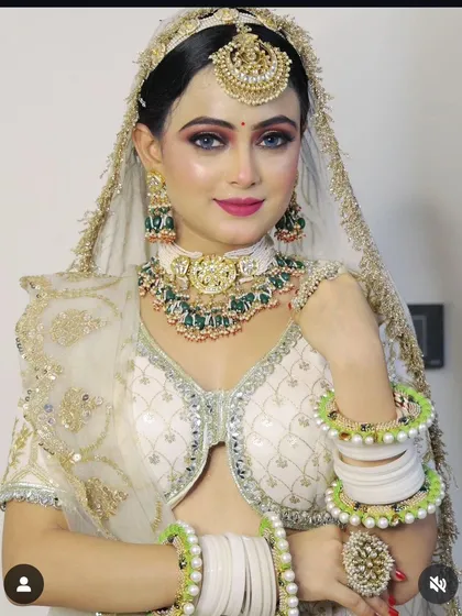 A bride wearing a white and green Kundan choker set with matching bangles. This is a fresh and elegant color combination for a modern bride.