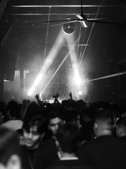 A black and white shot of the packed dance floor at Raahi, with spotlights cutting through the haze.