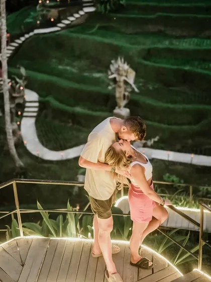 A romantic kiss overlooking the stunning terraced rice paddies in Bali. This destination pre-wedding photo combines a breathtaking landscape with an intimate moment.