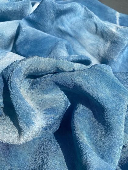 A close-up of the indigo-dyed crepe, showing the soft texture and the beautiful, watery patterns created by the tie-dye process.