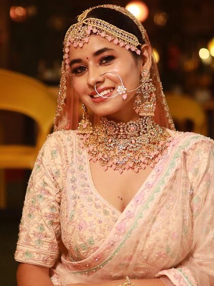 A close-up of the bride's face against a festive background. The makeup is soft and glowing, perfect for any celebration.