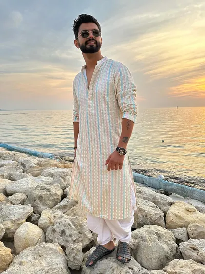 A classic Indian look with a striped kurta and dhoti pants, perfect for a sunset by the sea.